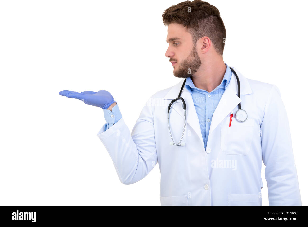Portrait of a Young smiling male doctor pointing finger away isolated on a white background Stock Photo