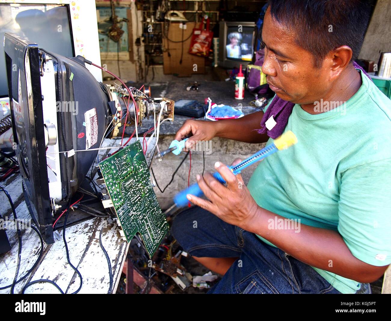 ANTIPOLO CITY, PHILIPPINES NOVEMBER 3, 2017 An electrician fixes an old television set in his