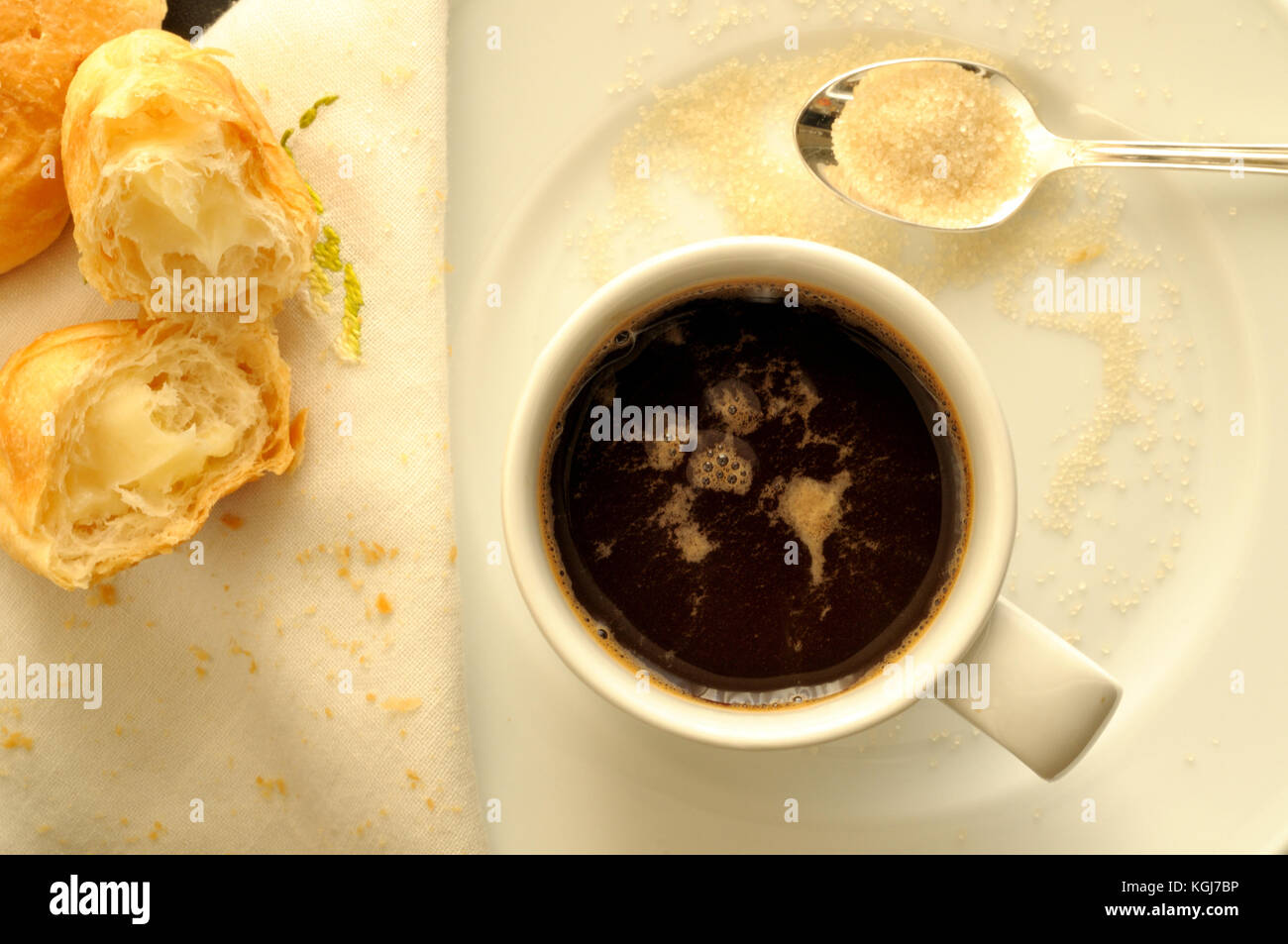 top view of a cup of espresso Italian, with a teaspoon of brown sugar and croissants filled with cream Stock Photo