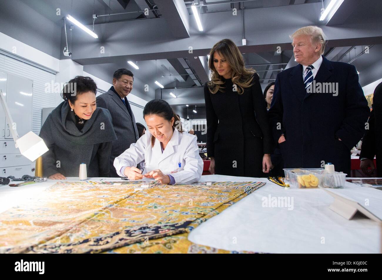 Seoul, South Korea . 08th Nov, 2017. U.S President Donald Trump, right, first lady Melania Trump, center, Chinese President Xi Jinping, and his wife Peng Liyuan, left, watch a conservationist repair an 18th century Imperial robe at the Conservation Scientific Laboratory during a tour of the Forbidden City November 8, 2017, in Beijing, China. Trump is on the third leg of a 13-day swing through Asia. Credit: Planetpix/Alamy Live News Stock Photo