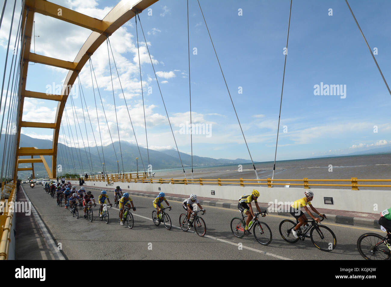 The rider flashed on the Fourth Bridge at the Tour de Central Celebes (TdCC) cycling race in Palu City, Central Sulawesi, Indonesia, Wednesday (08/11/2017). The cycling tour will cover a distance of 468.9 kilometers consisting of three stages across Tojo Unauna, Poso, Parigi Moutong, Sigi and Palu districts as many as three stages. ALAMY / Basri Marzuki Stock Photo