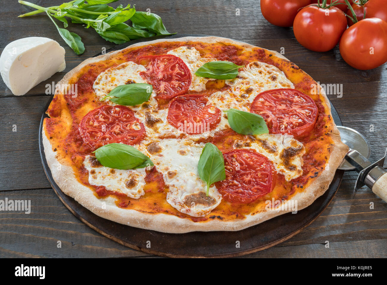 Fresh hot pizza on wood table with ingredients Stock Photo