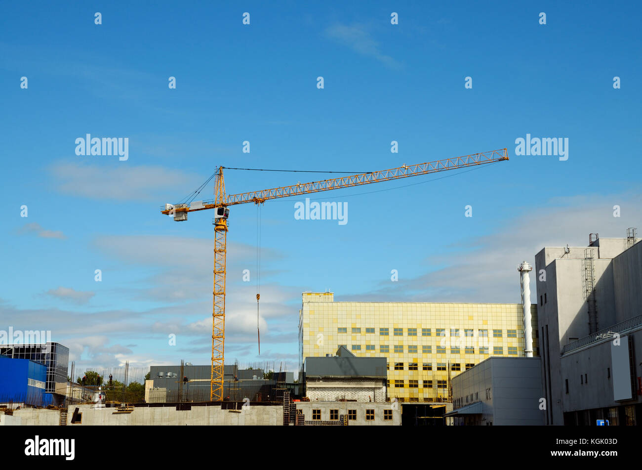 Construction crane lifts a load to the floors of the building Stock