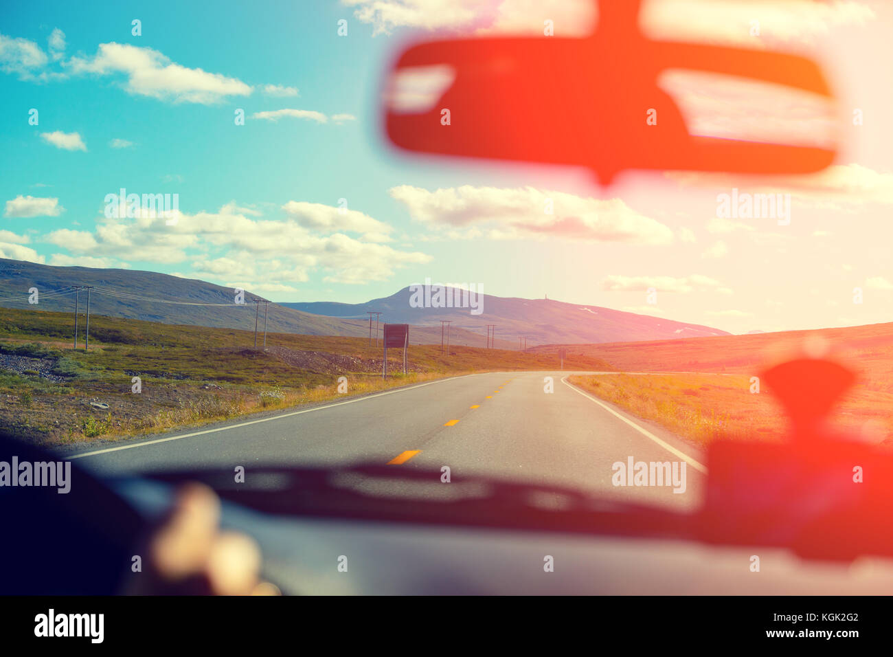 Driving a car on the mountain road at sunset. View from the windscreen ...