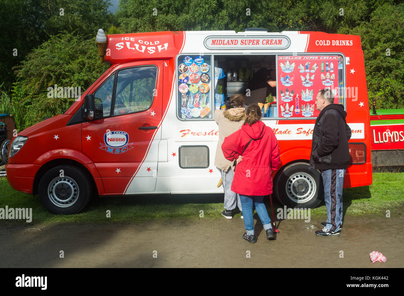 Traditional ice cream van with customers in a park, UK Stock Photo Alamy