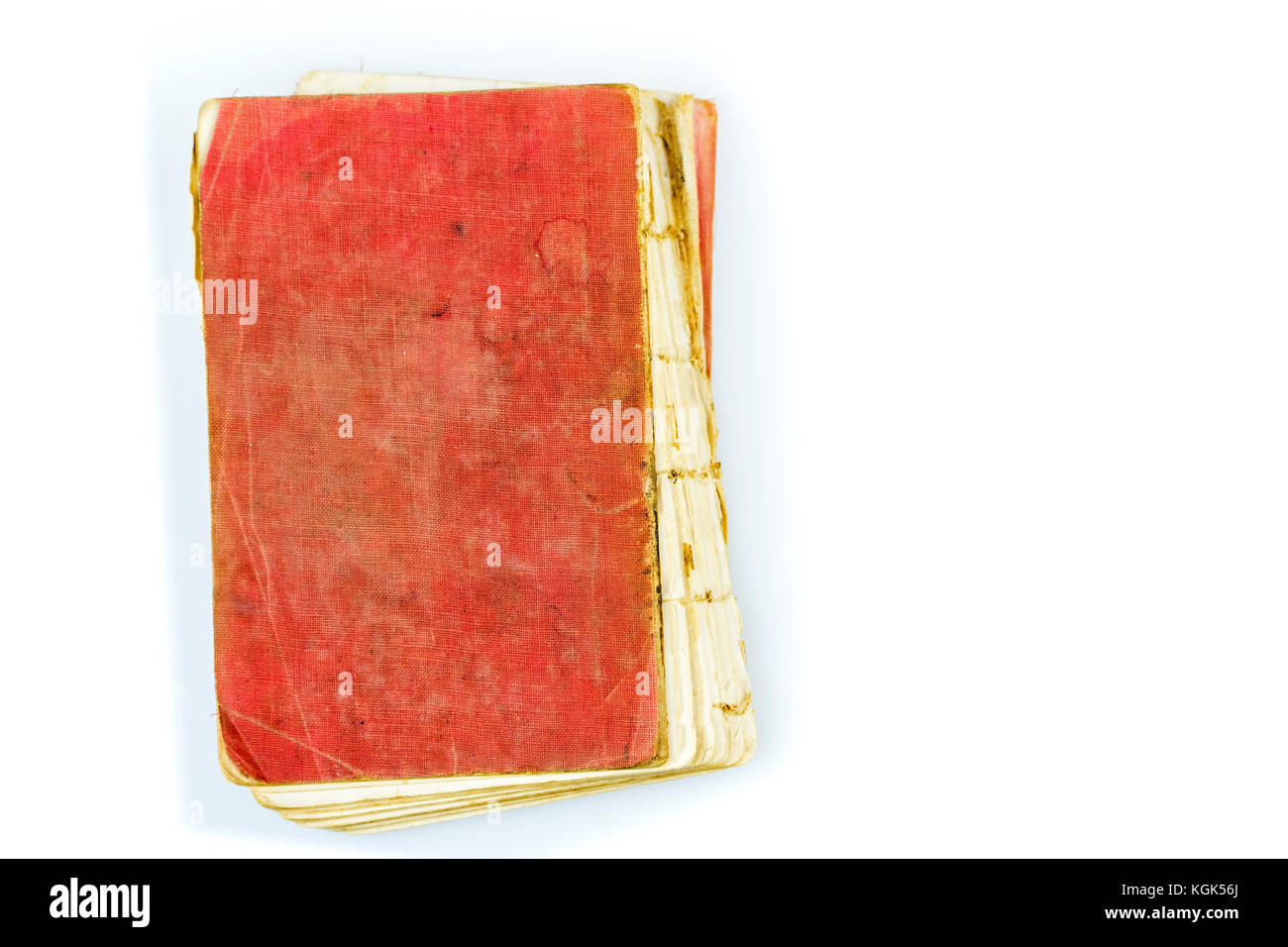 Old antique worn book with red stained cover on white. Vintage thread sewn print publication with torn out spine and visible threads. Stock Photo