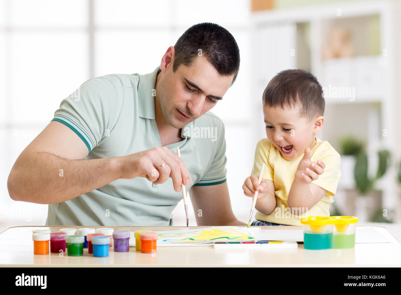 Father and child little boy of three years having fun painting at home Stock Photo