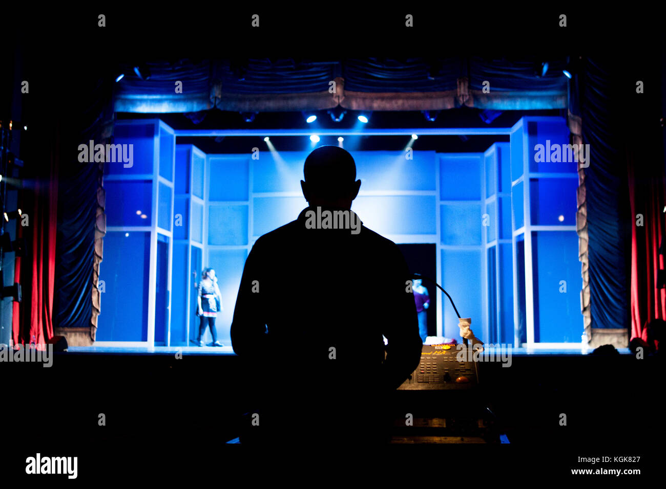 A light designer is checking the lights before the beginning of a theatre production. Stock Photo