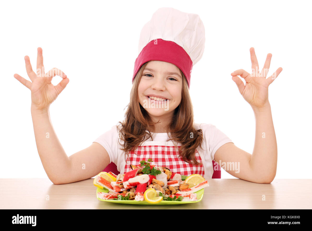 happy little girl cook with seafood and ok hand signs Stock Photo