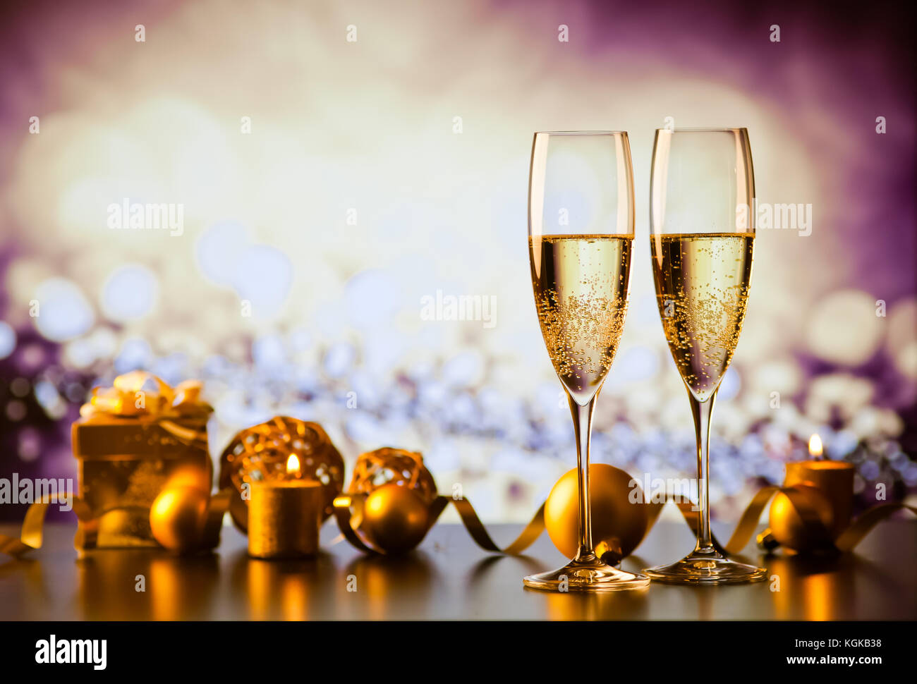 two champagne glasses against holiday lights and fireworks - new year ...