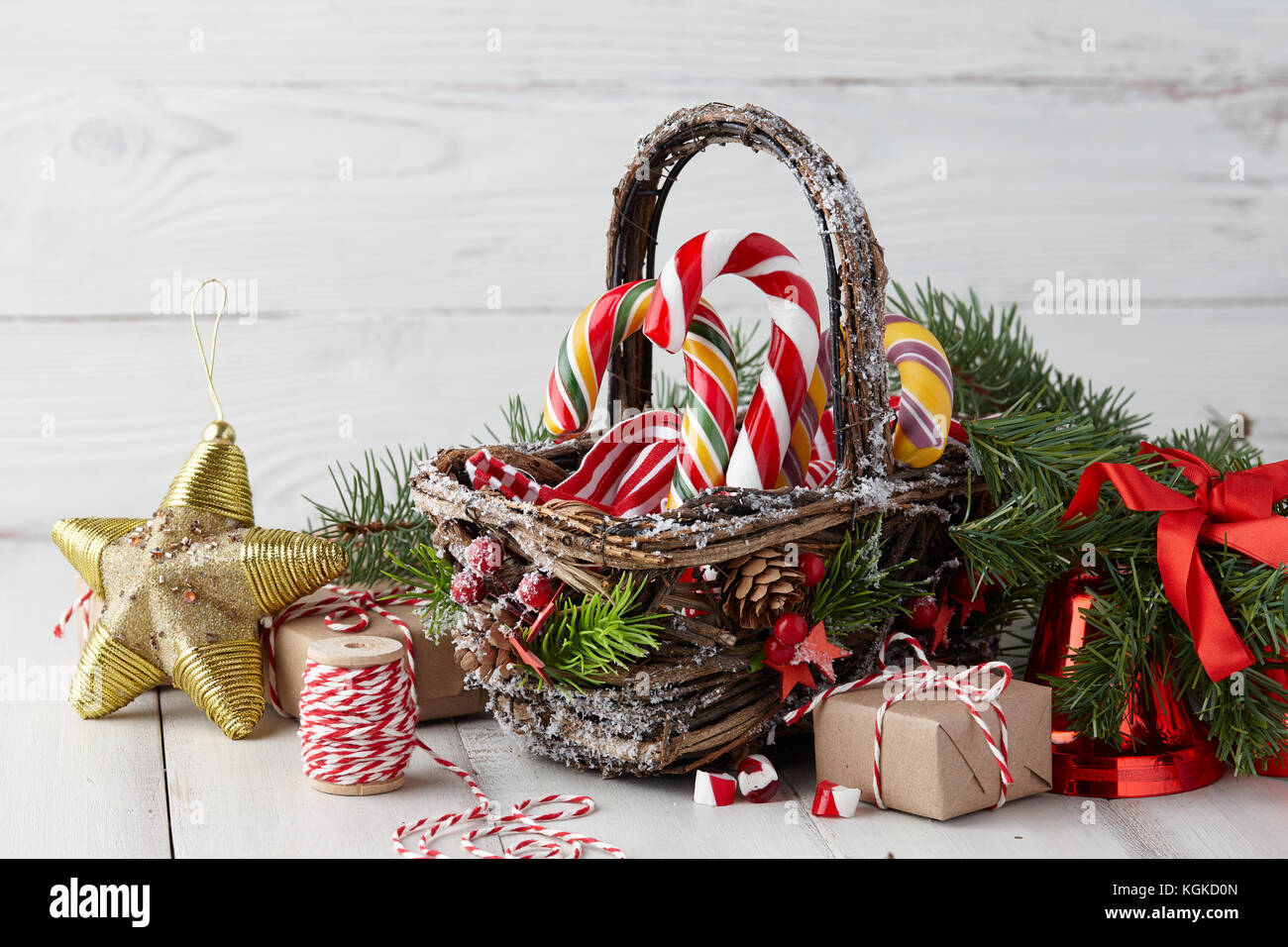 Christmas basket with candy canes on white planks Stock Photo Alamy
