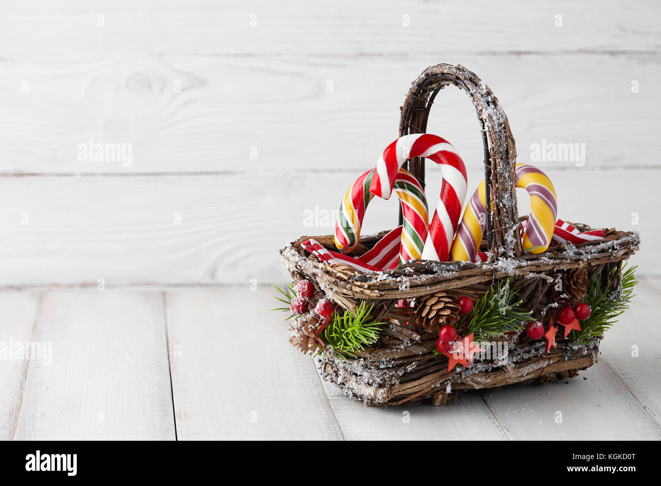 Christmas basket with candy canes on white planks Stock Photo Alamy