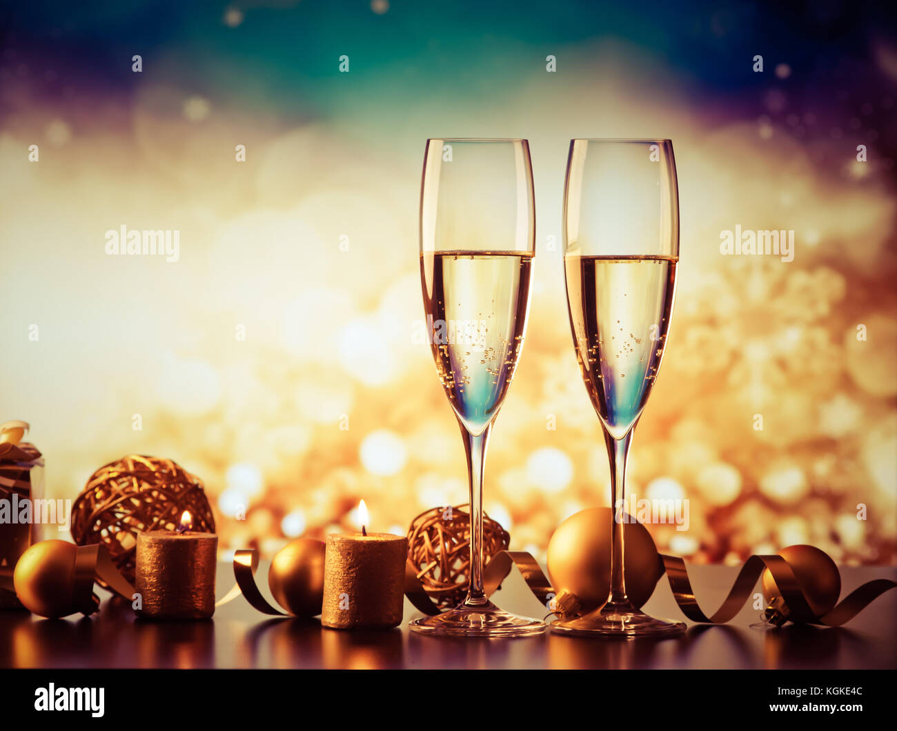 two champagne glasses against holiday lights and fireworks - new year ...