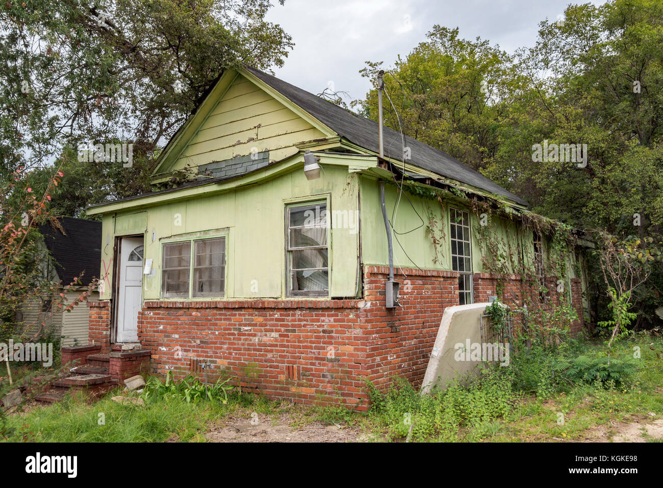 Boarded up, abandoned, house showing urban decline, decay, blight, and American poverty in Montgomery, Alabama USA. Stock Photo