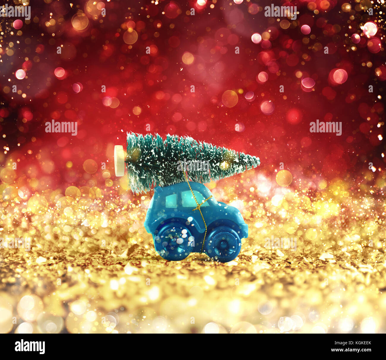 Toy car that transport a Christmas tree on a glowing gold and red