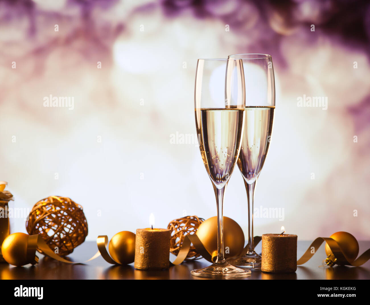 two champagne glasses against holiday lights and fireworks - new year ...