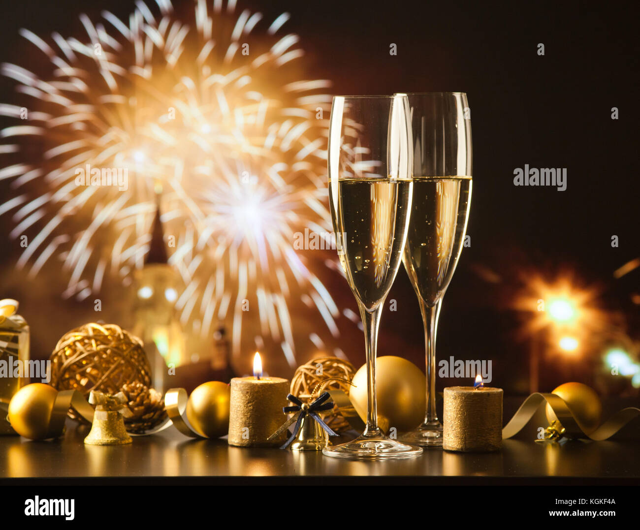 two champagne glasses against holiday lights and fireworks - new year ...