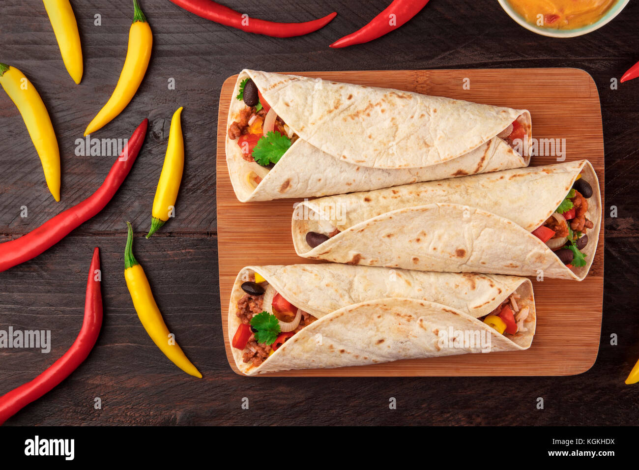 Mexican burritos with cheese salsa, and chili peppers Stock Photo Alamy