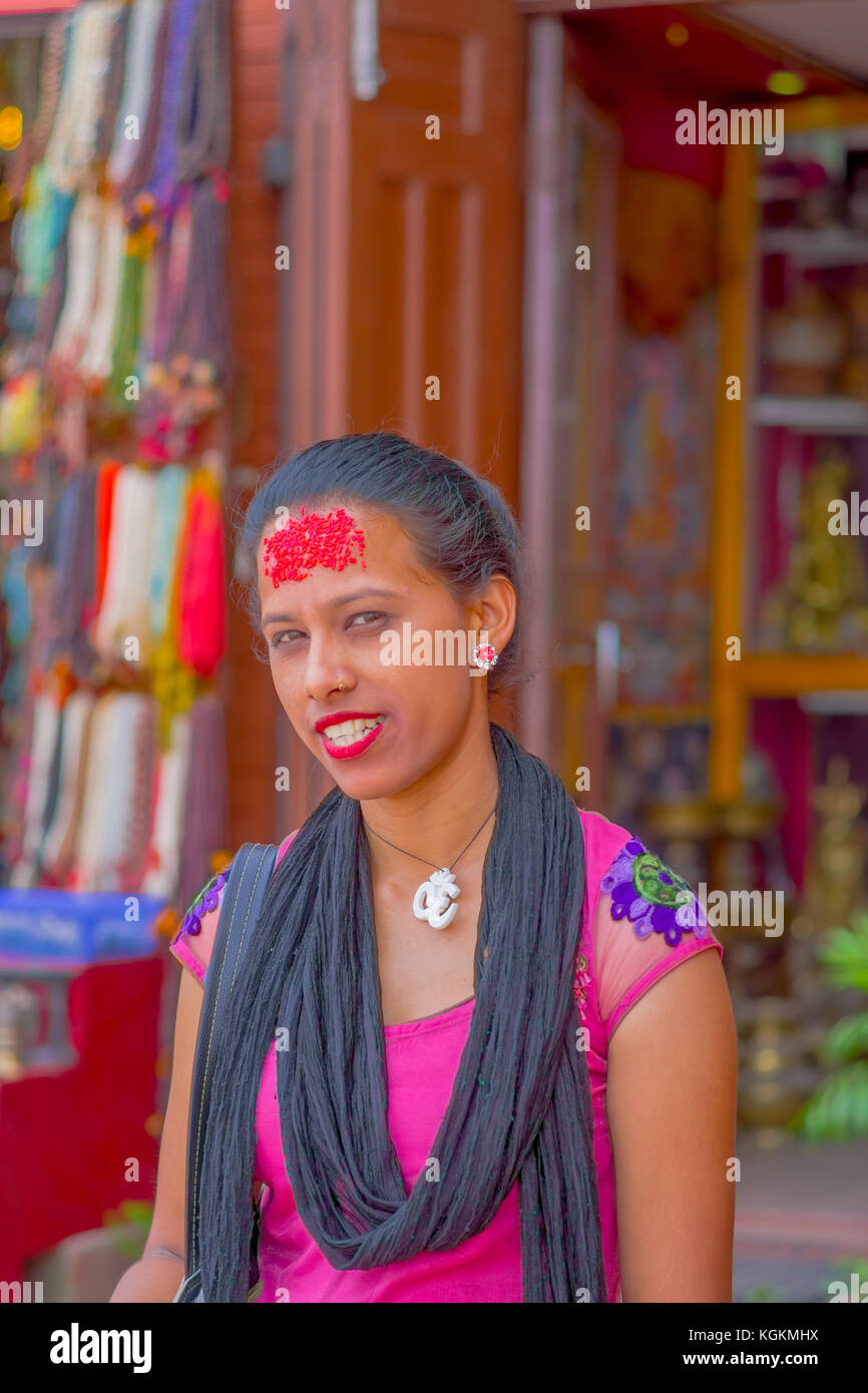 KATHMANDU, NEPAL OCTOBER 15, 2017: Portrait of women in traditional dress with red pieces of rice in her forehead, in Kathmandu, Nepal in a blurred background Stock Photo