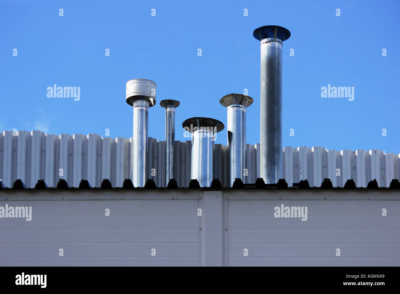Five chimney pipe from stainless steel on the roof of the house Stock