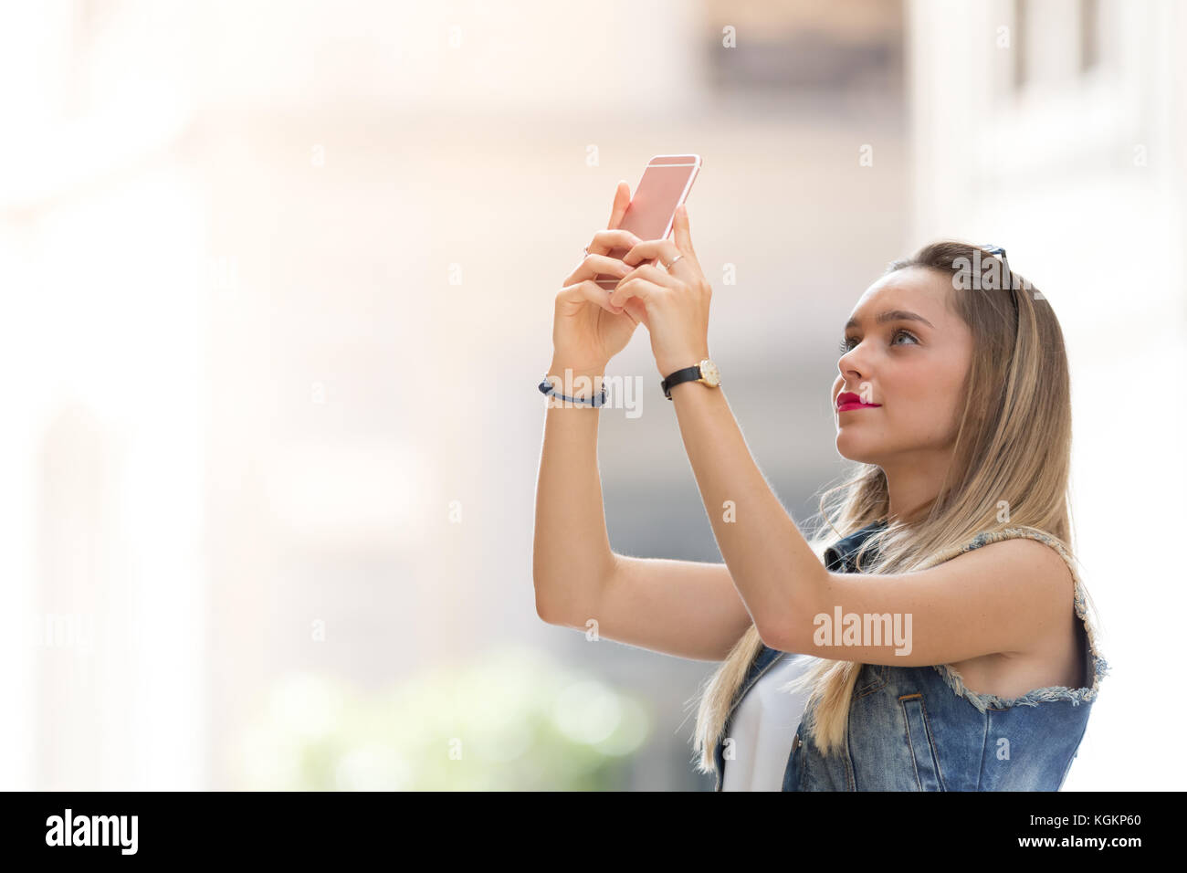 Pretty blonde teenager taking a photo with her mobile phone Stock Photo