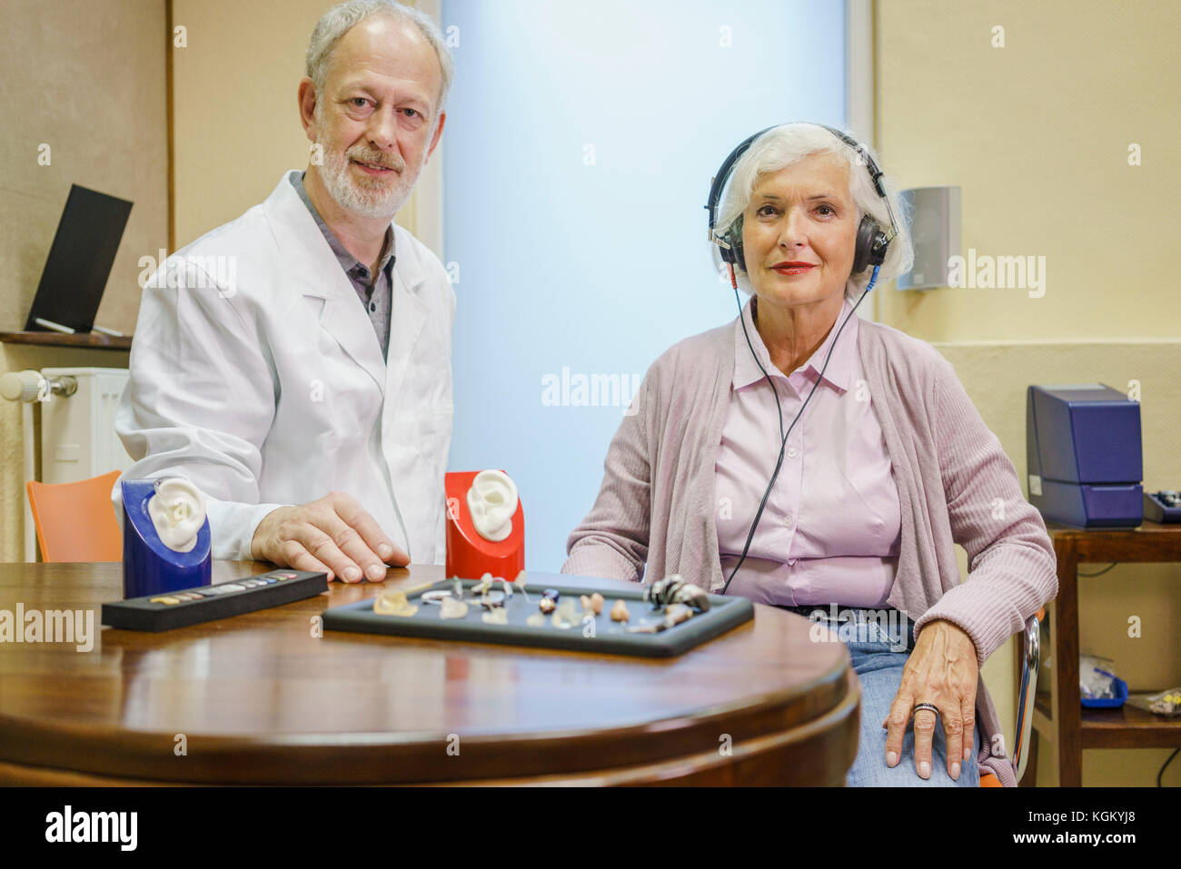 Portrait of audiologist and senior patient wearing headphones during ear exam at clinic Stock Photo