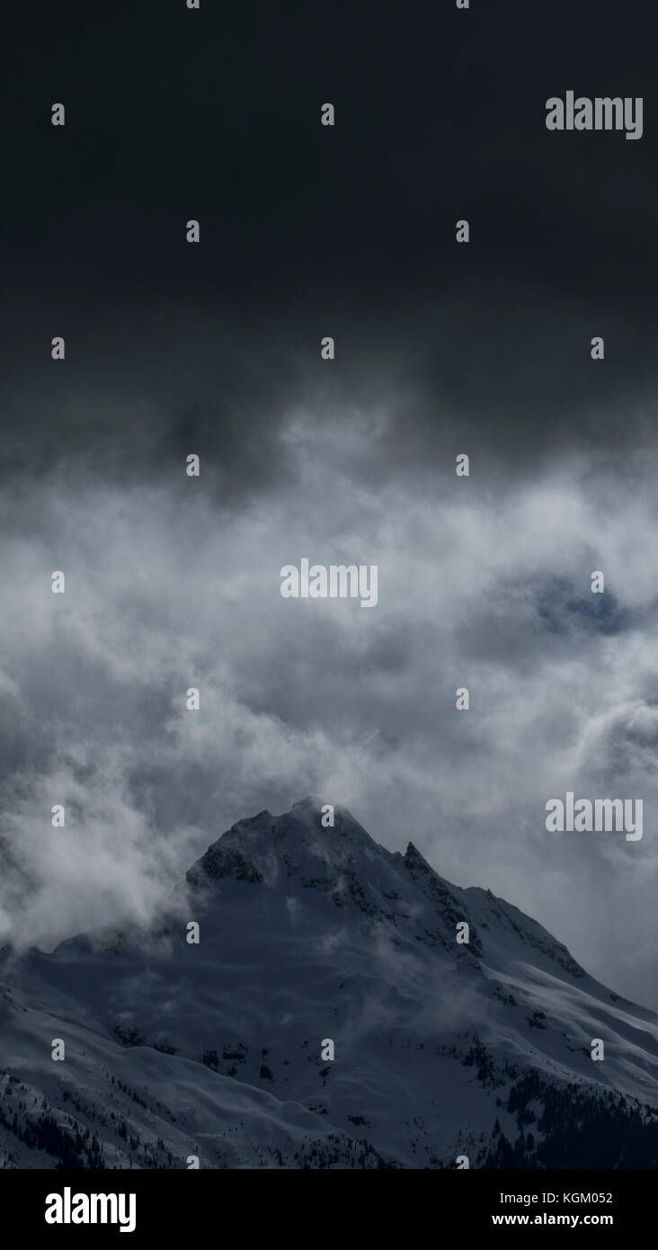 Low angle view of snowcapped mountain against cloudy sky, Tantalus, British Columbia, Canada Stock Photo