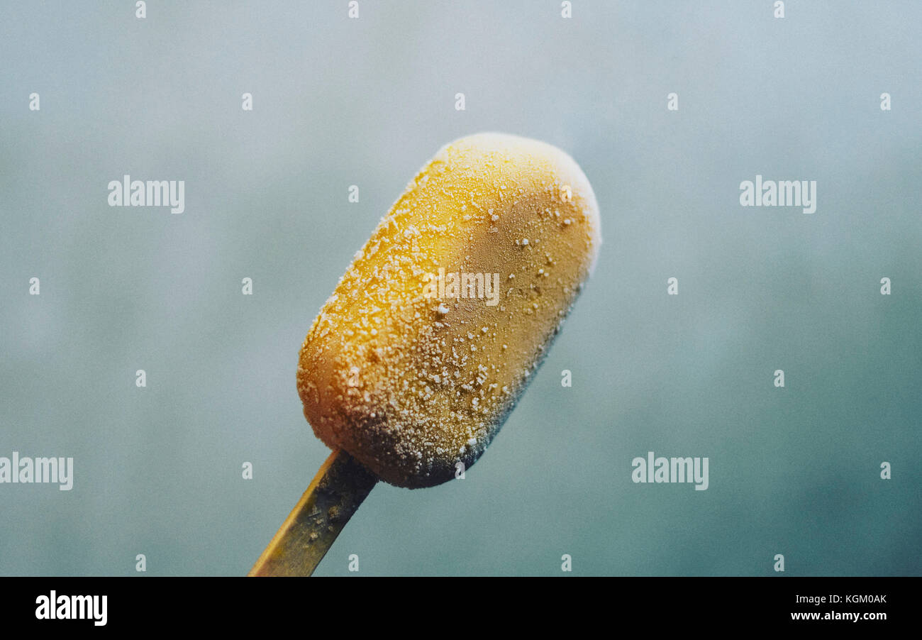 Close-up of yellow ice cream on stick Stock Photo