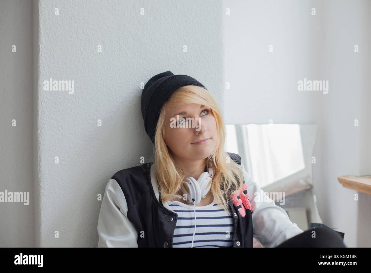 Woman sitting against white wall hi-res stock photography and images ...