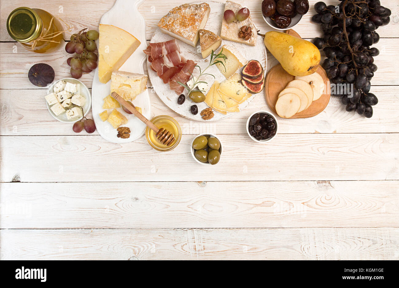 Overhead of cheese plate with pieces moldy cheese, prosciutto, pickled