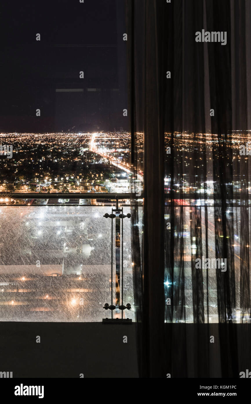 Illuminated cityscape seen through curtains on window, Las Vegas, Nevada, USA Stock Photo