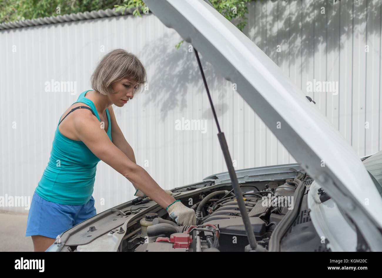 Mature woman repairing breakdown car Stock Photo
