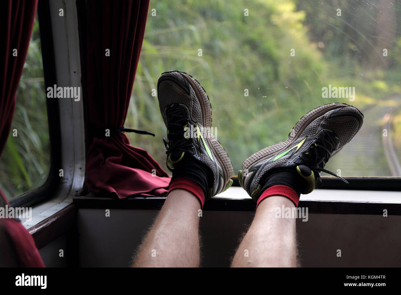Central Province Sri Lanka Man with feet up on window edge on train travelling through the Hill Country Stock Photo