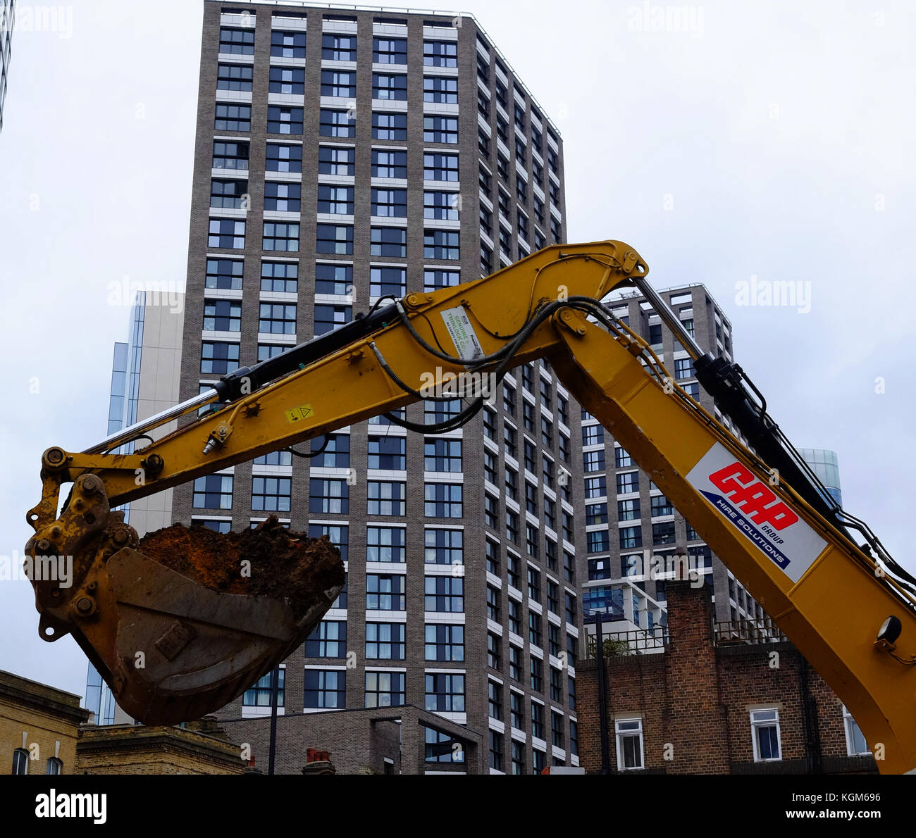 A mechanical digger at work in a building site in the East End of Londion Stock Photo