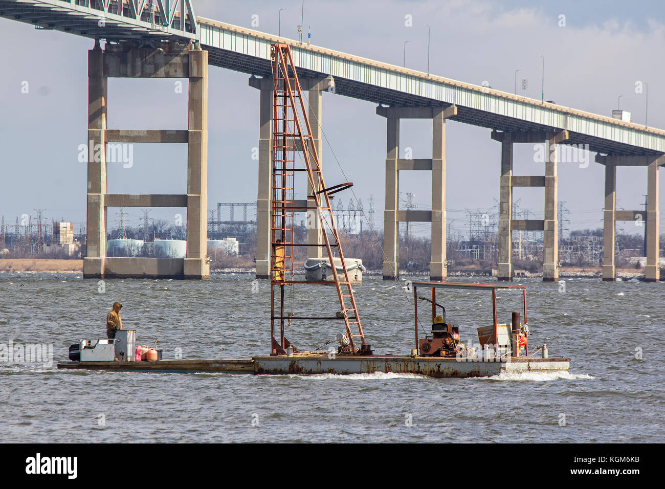 Small powered barge with pile driver derrick near Francis Scott Key Bridge in Baltimore Stock Photo