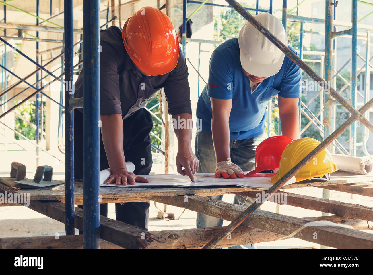Construction concepts, Engineer and Architect working at Construction Site with blueprint, Vintage Effect Stock Photo