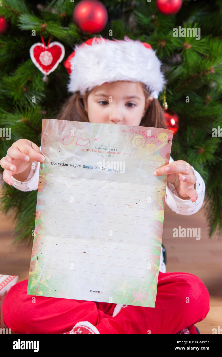 Little girl showing The Three Wise Men Letter. She painted a sheet with header in Spanish Stock Photo