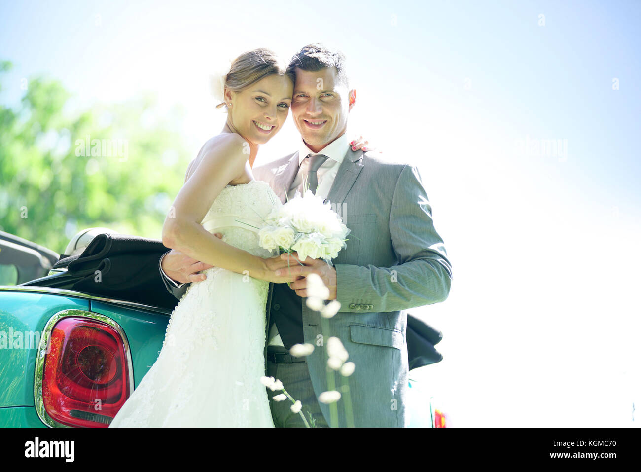 Bride and groom standing by convertible car on their wedding day Stock ...