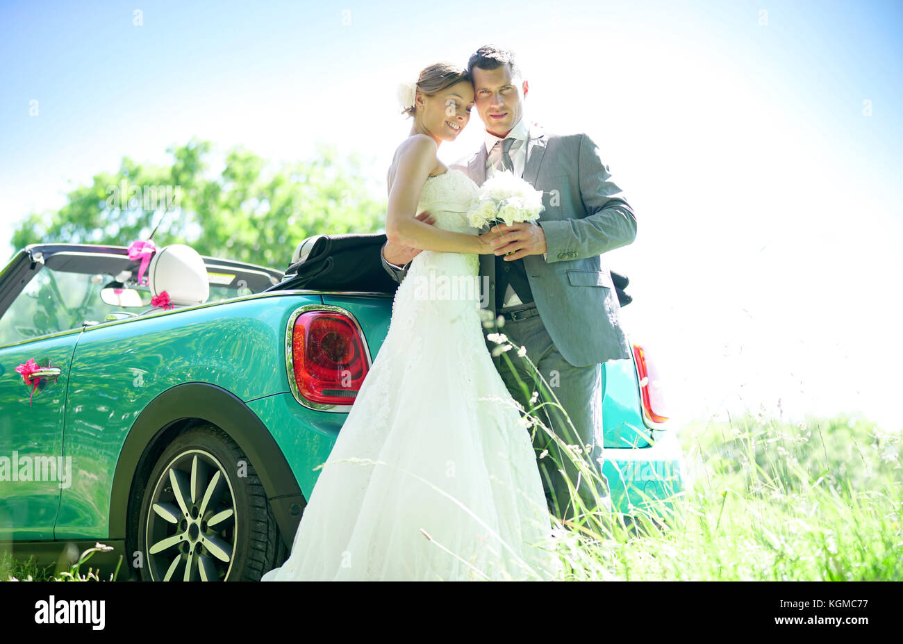 Bride and groom standing by convertible car on their wedding day Stock ...