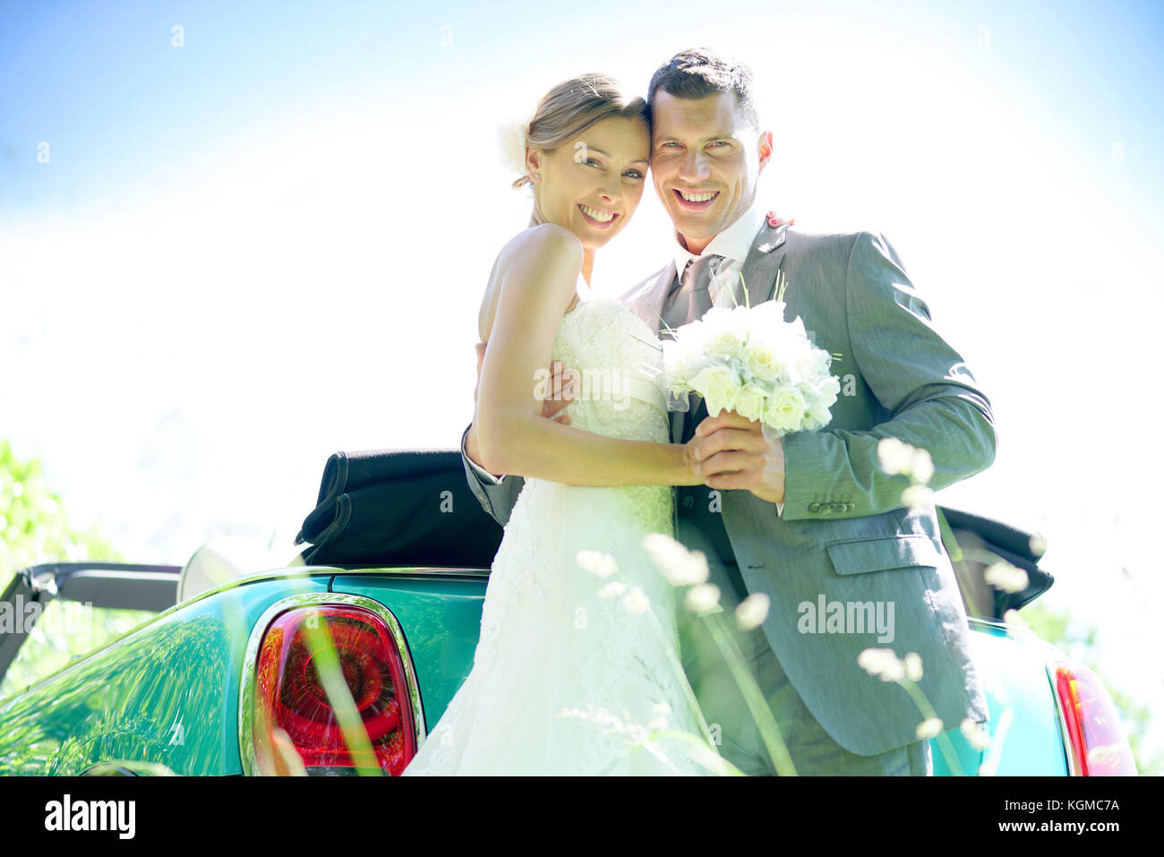 Bride and groom standing by convertible car on their wedding day Stock ...