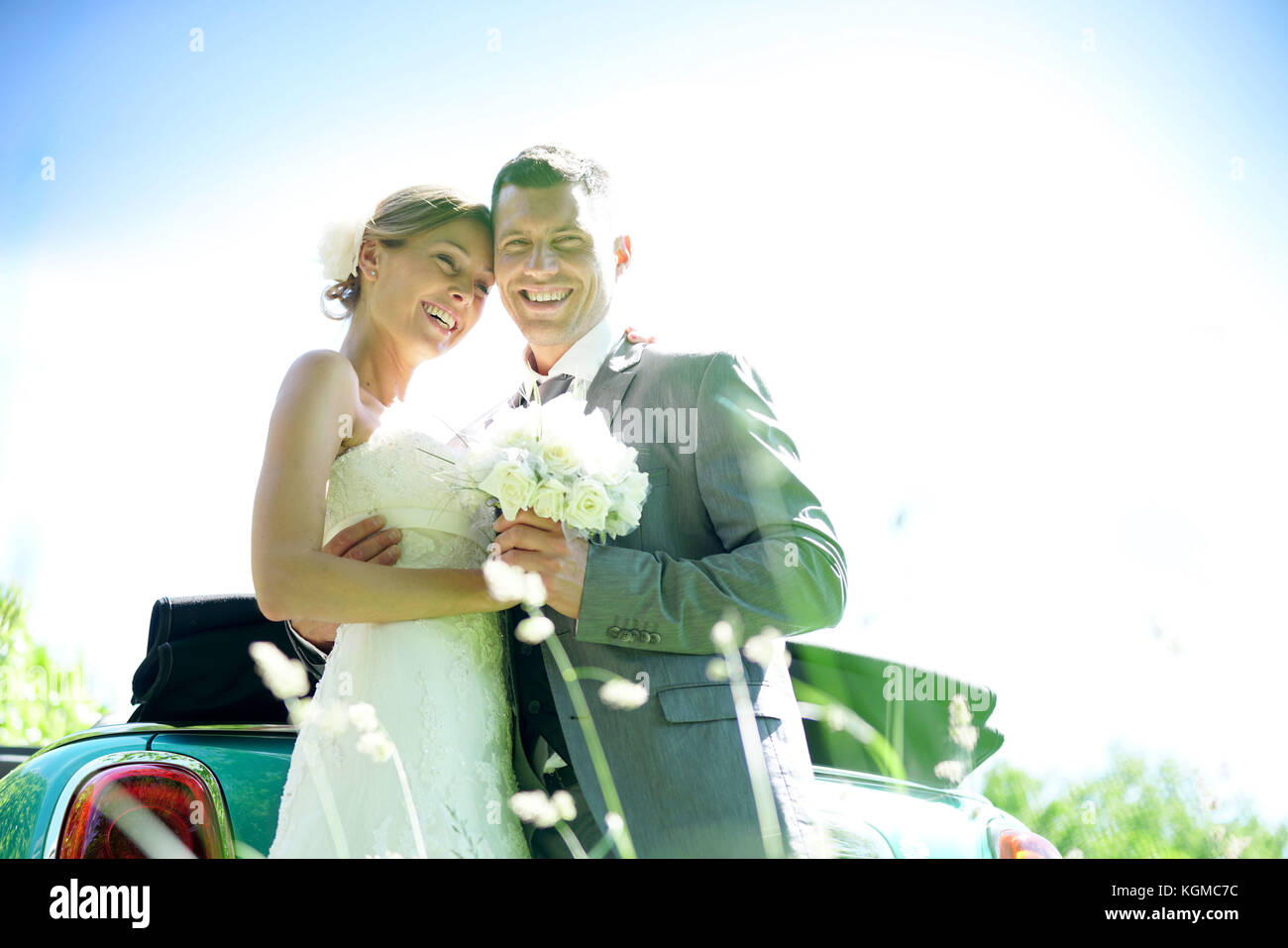 Bride and groom standing by convertible car on their wedding day Stock ...