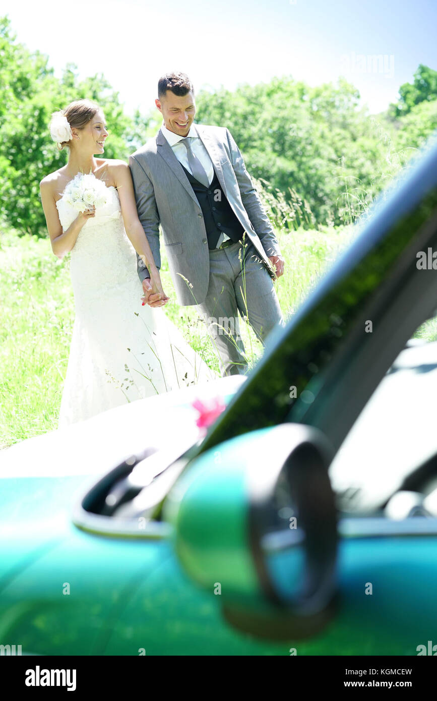 Bride and groom walking towards convertible car Stock Photo - Alamy