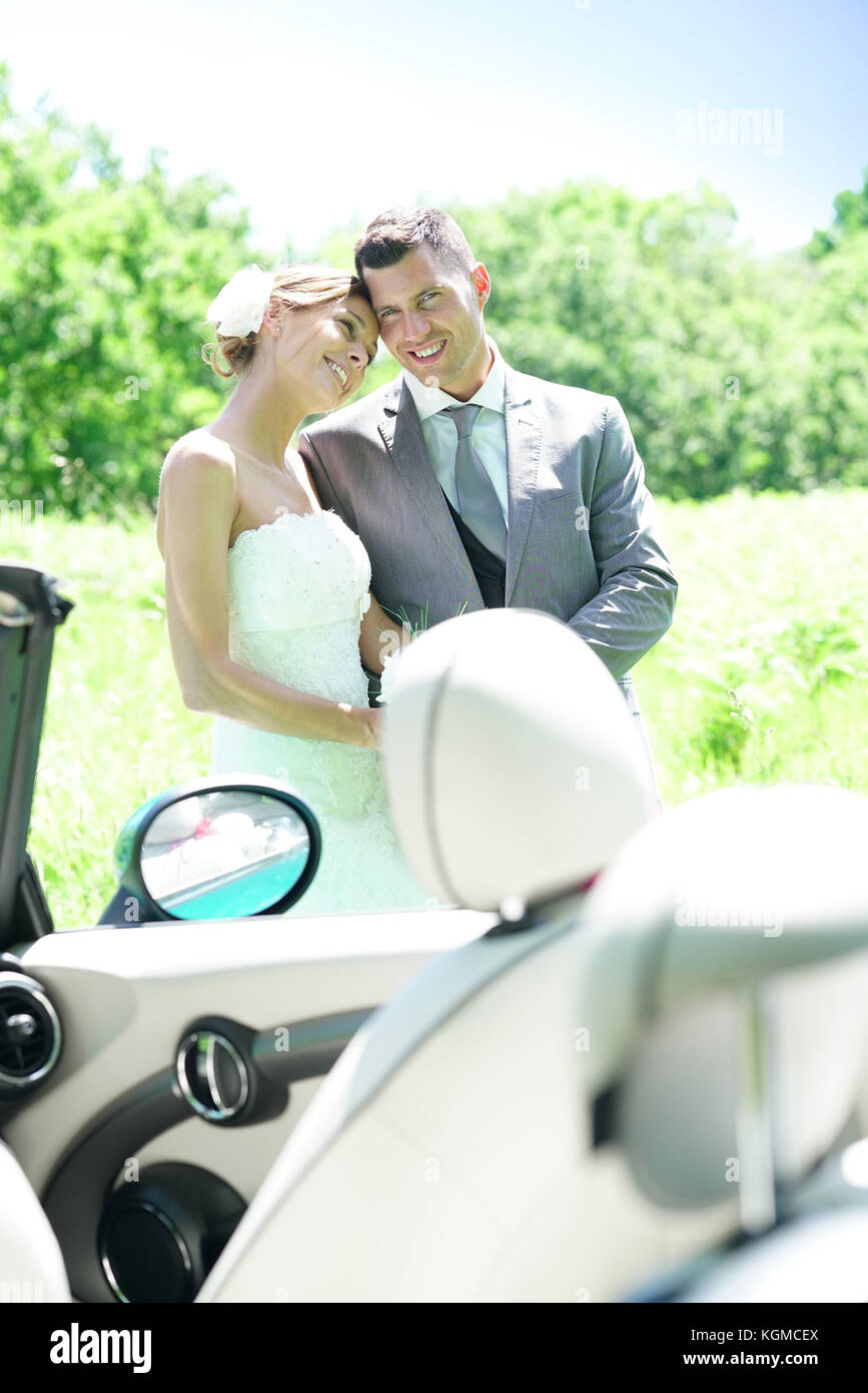 Bride and groom walking towards convertible car Stock Photo - Alamy
