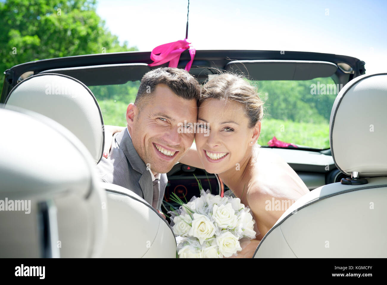Bride and groom sitting in convertible car Stock Photo - Alamy
