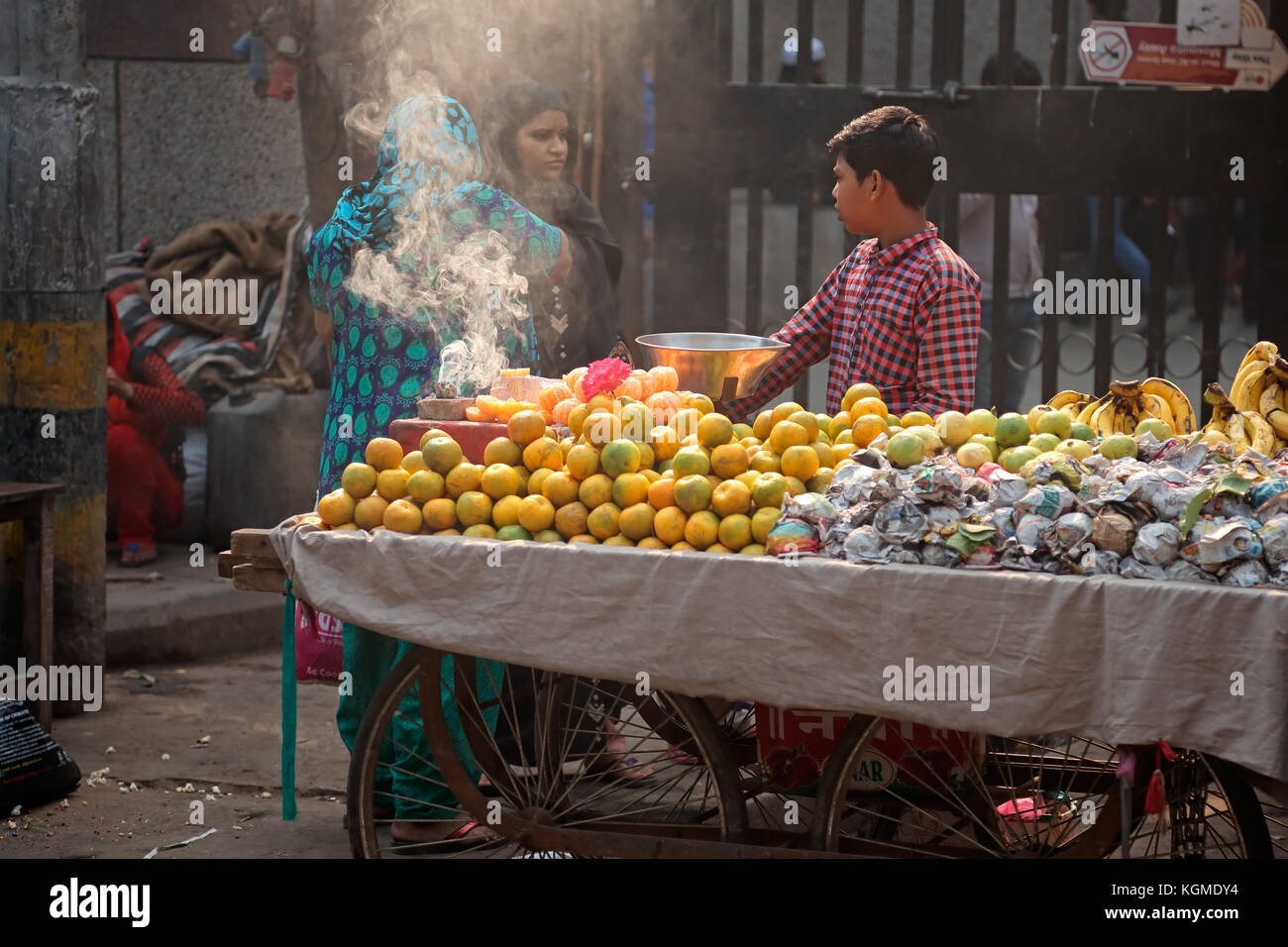 Delhi, India - November 20, 2015: An Indian boy selling his fresh produce on a crowded street market of Old Deli Stock Photo