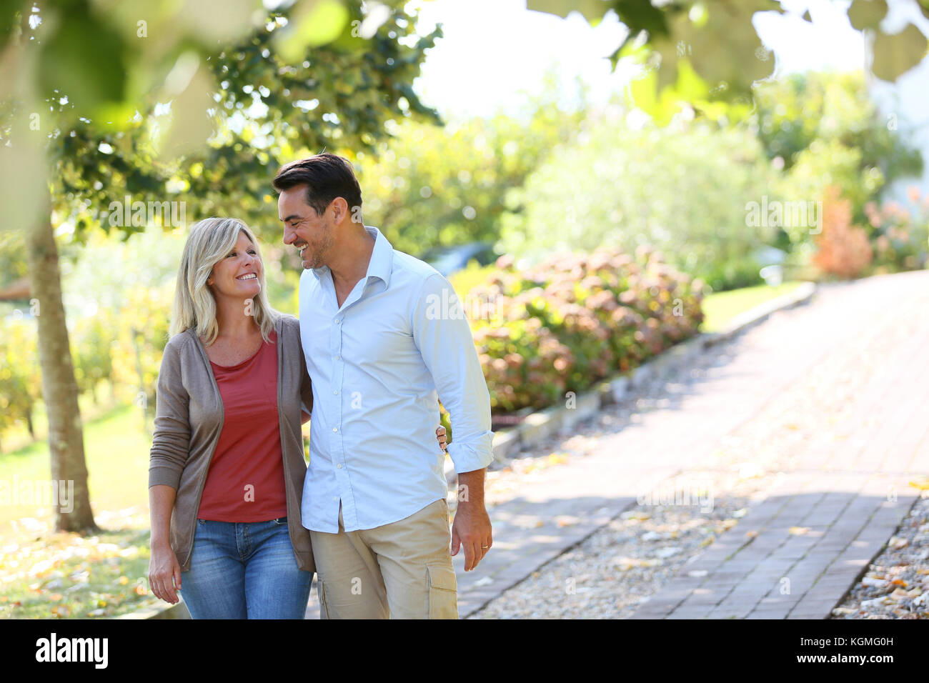 Couple walking hand in hand in park Stock Photo - Alamy