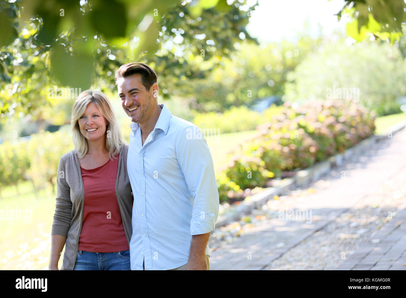 Couple walking hand in hand in park Stock Photo - Alamy