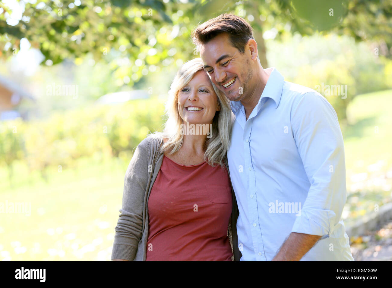 Couple walking hand in hand in park Stock Photo - Alamy