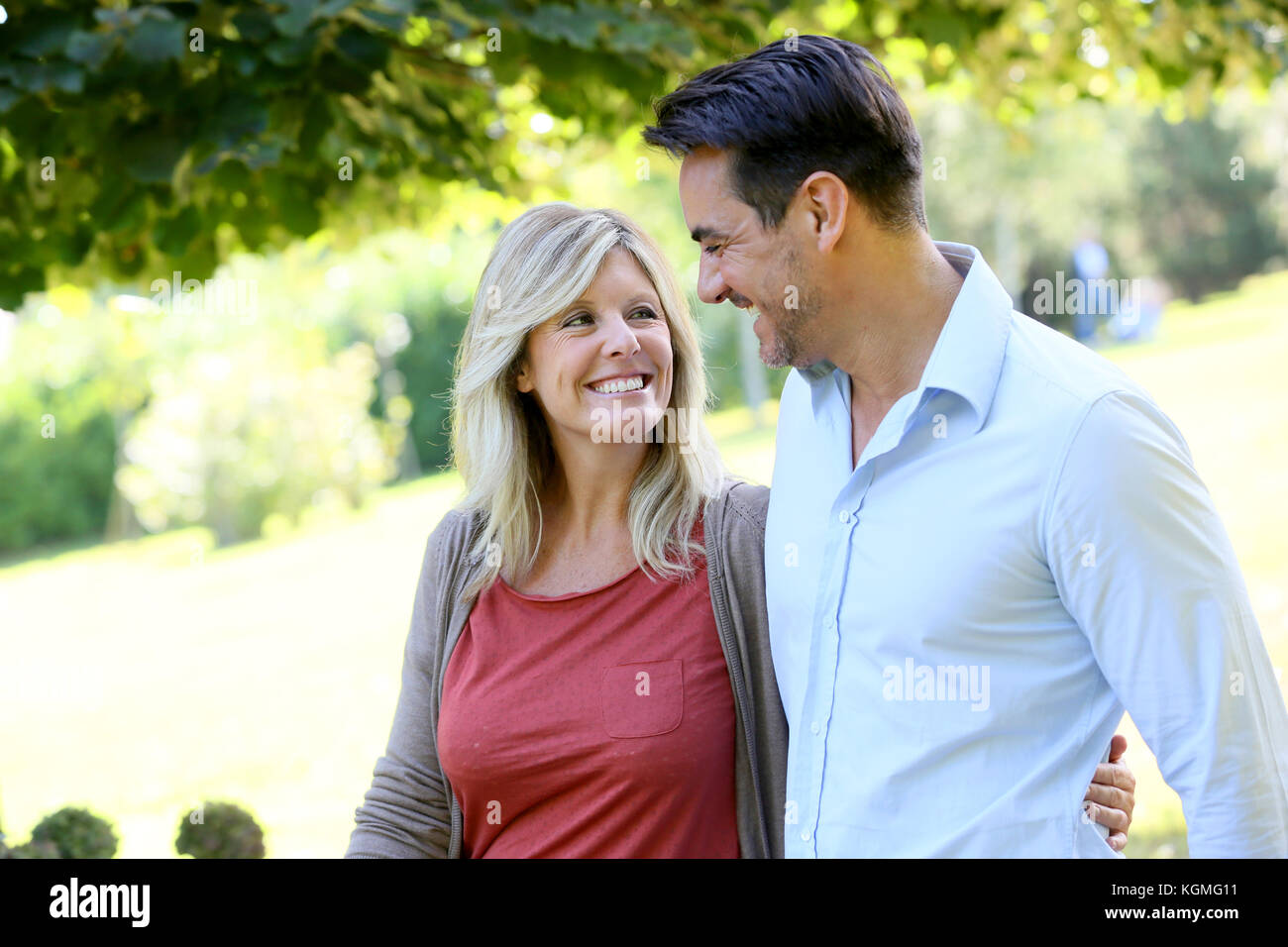 Couple walking hand in hand in park Stock Photo - Alamy