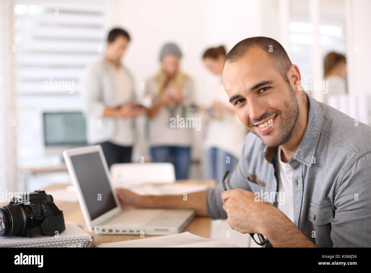 Cheerful reporter working in office on laptop Stock Photo - Alamy